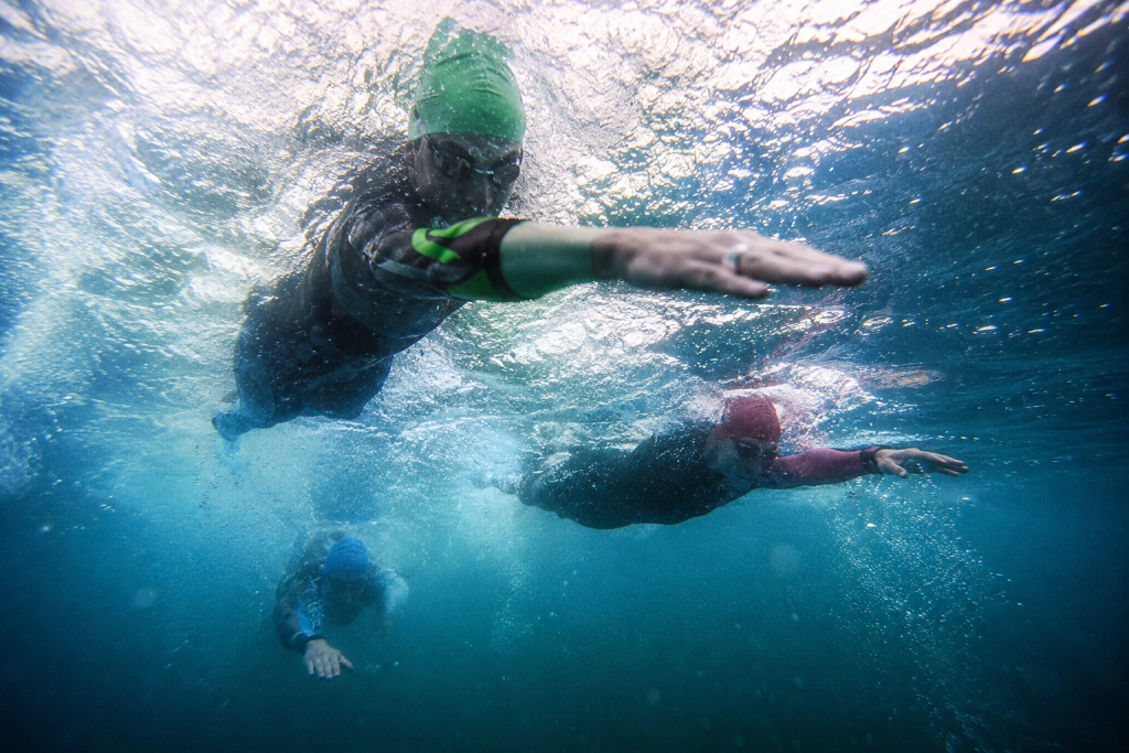 Triathlon-Disziplin Schwimmen: Mehrere Schwimmer:innen in Gewässer.